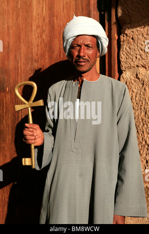 Egyptian man holding the entrance key (Ankh) to the Temple of Ramesses II at Abu Simbel, Egypt Stock Photo