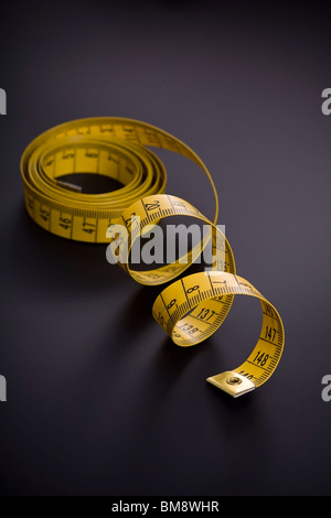Tape Measure on black background. Selective focus. Stock Photo