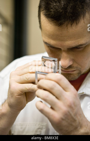 Recyclable composite textile fabrication department of factory, worker using a pick counter to inspect thread Stock Photo
