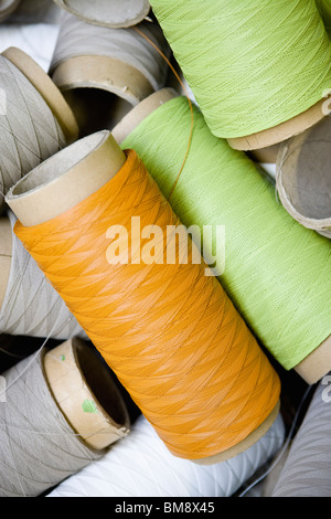 Recyclable composite textile fabrication department of factory, reels of excess coated thread Stock Photo