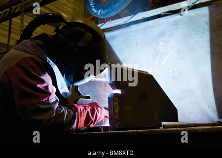 Coated textile plant, maintenance workshop, welder performing arc welding Stock Photo