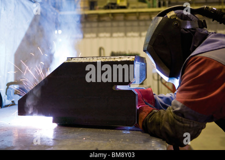 Coated textile plant, maintenance workshop, welder performing arc welding Stock Photo