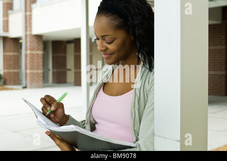 Female college student writing in notebook Stock Photo