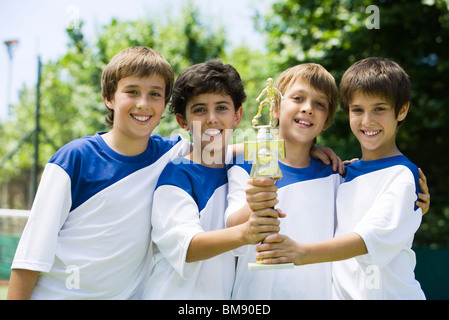 Young soccer teammates holding trophy together, portrait Stock Photo