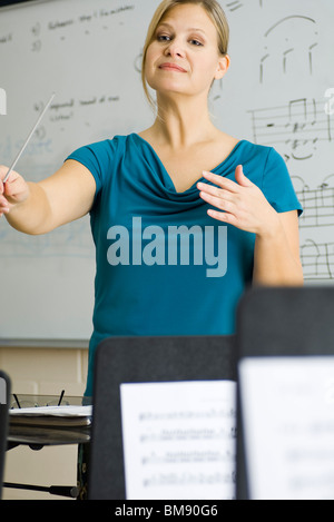 Music teacher with baton and note stand on white background Stock Photo ...