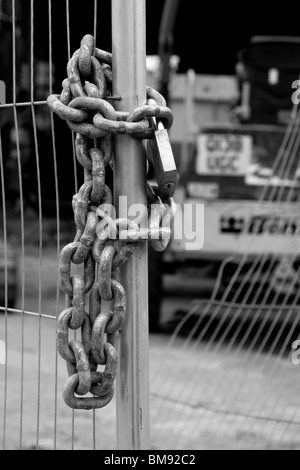 Padlock and chain on a builder's fence Stock Photo