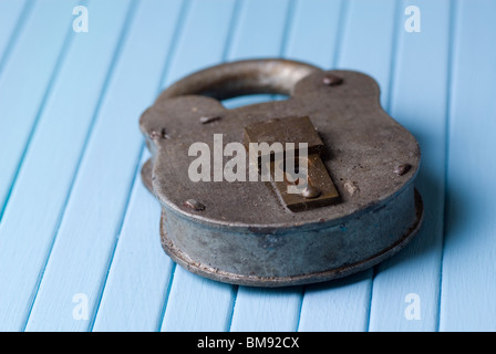 Old rusty lock on blue wooden background Stock Photo