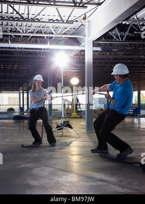 Engineers Playing Tug Of War On Construction Site Stock Photo