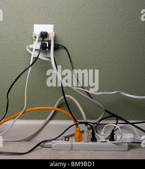 Multiple electrical plugs in overloaded wall outlet Stock Photo