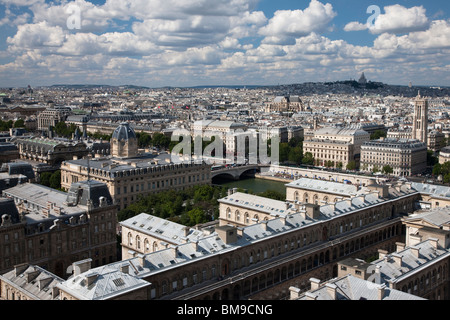 Aerial city view of Paris rooftops from Ile De la Cite toward Montmartre with dramatic blue sky and puffy cloud background Stock Photo