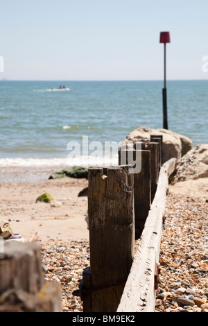 wooden beach groyne on beach with sea Stock Photo