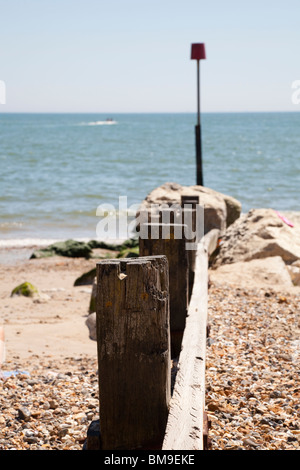 wooden beach groyne on beach with sea Stock Photo