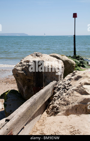 wooden and stone groyne with marker poll on beach at Mudeford Stock Photo