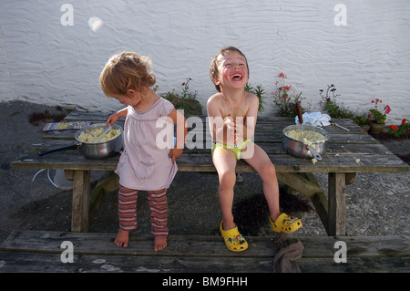 Two young children laughing with each other on holiday in Cornwall, England, UK Stock Photo