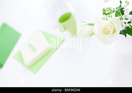 Vase of white roses on desk in office, differential focus Stock Photo