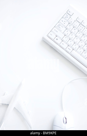 Computer keyboard, computer mouse and toy airplane on white background Stock Photo