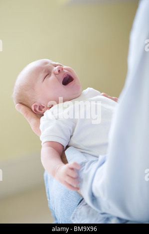 Man holds crying two week old newborn baby Stock Photo