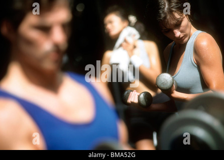Woman lifting weights at gym. Stock Photo