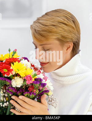 Portrait of Woman smelling bouquet of flowers Stock Photo