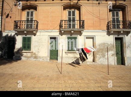 Mdina, Malta, washing hangs on a washing line in the street in front of a typical Maltese house. Stock Photo