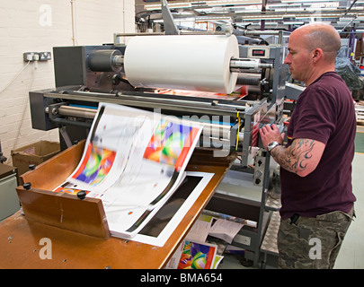 Laminating machine with laminated sheet of paper speeding off roll ...