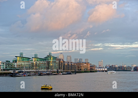 Typical luxury Thames riverside development, Wapping, East End, London, England, UK, with Canary Wharf in the background Stock Photo
