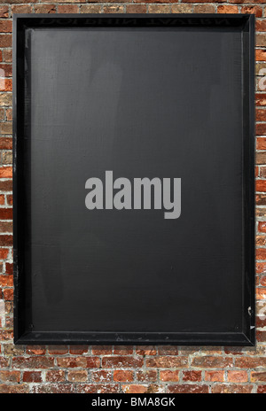Blank blackboard menu sign on a red brick wall. Stock Photo