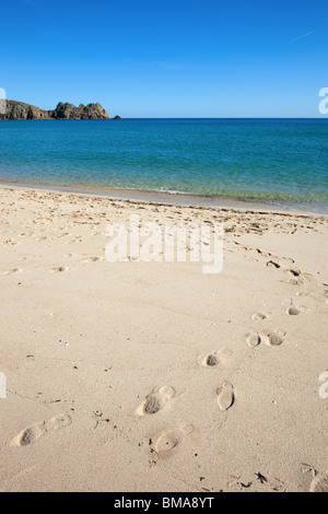 Porthcurno sandy beach and Logan rock in Cornwall UK. Stock Photo