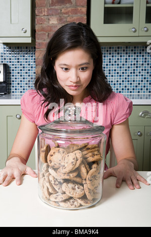 Young woman with cookie jar Stock Photo