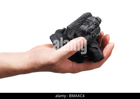 Man holding lumps of charcoal in his hand Stock Photo