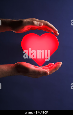 Man holding glowing red heart Stock Photo - Alamy