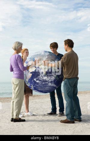 Ecology concept, four people placing hands on earth together