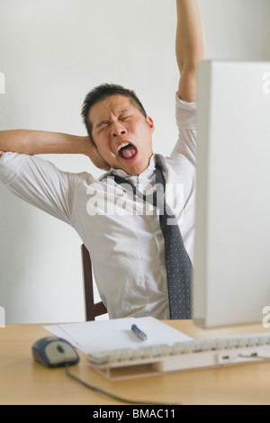 Businessman Yawning at Desk Stock Photo