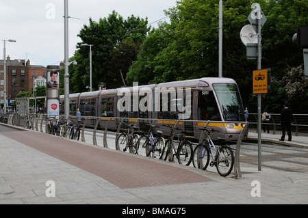 LUAS Light Railway transit system train at St Stephens Green Dublin Ireland Bicycles parked on the barrier Stock Photo