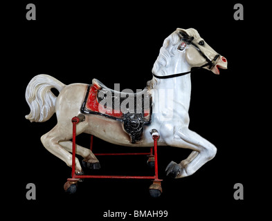 Rocking horse. Old metal antique rocking horse on wheels against a black ground Stock Photo