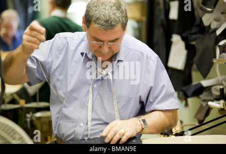 A tailor in the workshop of Henry Poole in Savile Row, London. Stock Photo