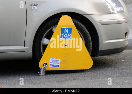 Wheel clamp in place on an illegally parked Toyota car on a Dublin street Stock Photo
