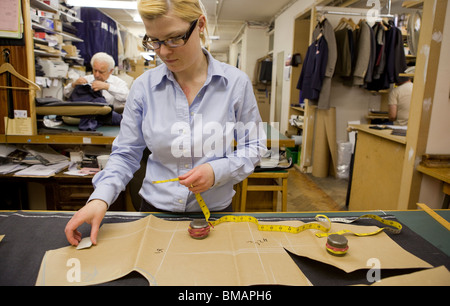 Tailors working in the workshop of Stowers Bespoke, in Savile Row, London. Stock Photo
