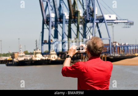 A man taking a photograph of the Port of Felixstowe in Suffolk.  Photo by Gordon Scammell Stock Photo