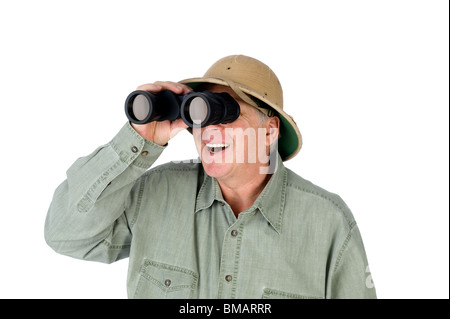A mature adult man wearing a pith helmet looks through a pair of binoculars. Stock Photo