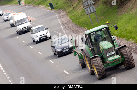 A queue of traffic behind a slow moving vehicle tractor on the A75 road ...