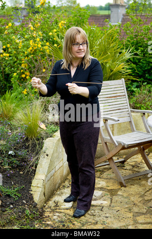 A woman using copper Dowsing rods which are used to find water sources. Stock Photo