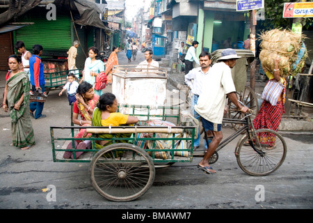 Street scene ; cycle rickshaw riders with passengers ; Calcutta now Kolkata ; West Bengal ; India Stock Photo