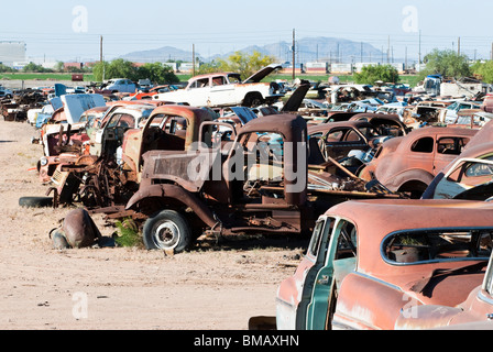 old vehicles in an auto salvage yard being recycled for parts and scrap metal Stock Photo
