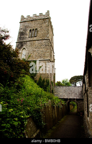 Entry path showing the tower and gravestones at Talland Parish Church near Looe in Cornwall, UK Stock Photo