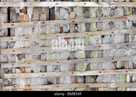 Concrete ruined wall, reinforced wooden lattice - background Stock Photo