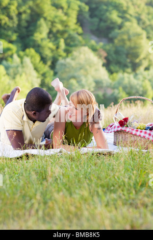 portrait of young multiethnic couple picnicking in park Stock Photo