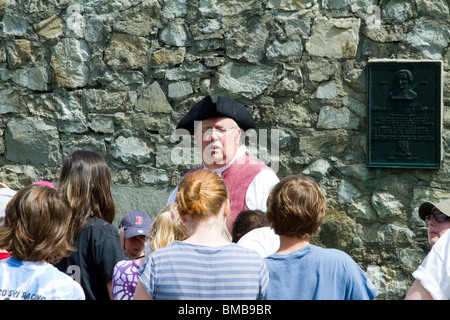 A period dressed costumed guide at Fort Ticonderoga, New York  with a group of children. Teaching and lecturing. Stock Photo