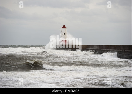 Wave breaking over Berwick upon Tweed lighthouse, Northumberland, England, UK, on a stormy winter day Stock Photo