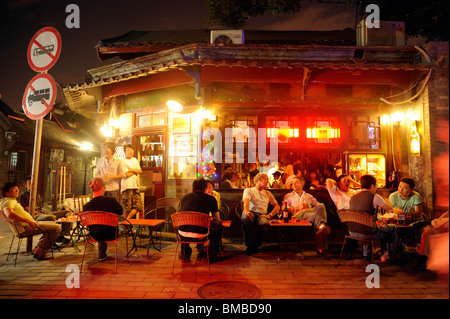 People drinking outside a bar at Nan Luo Gu Xiang in Beijing, China. 2010 Stock Photo